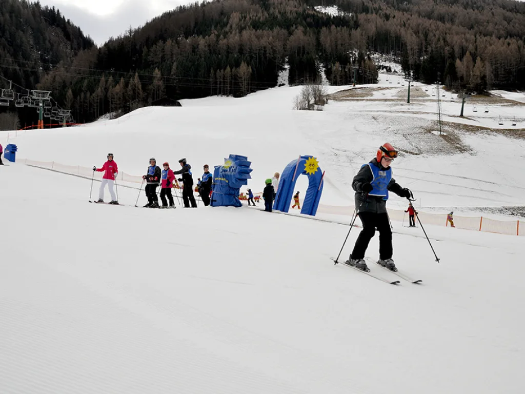 Skifahrende auf der Piste neben den Übungselementen.